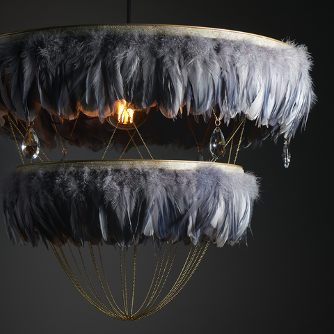 Grey feather lightshade with crystals and brass chains. Two tiered feather lamp shade on a dark background. Beautiful feather lighting